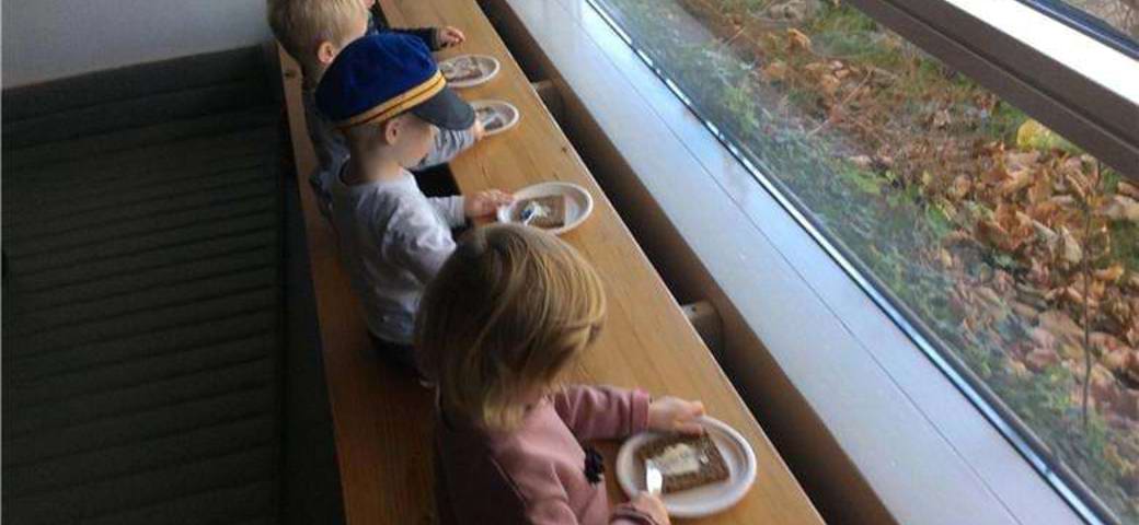 børn smører rugbrødsmadder ved vinduet