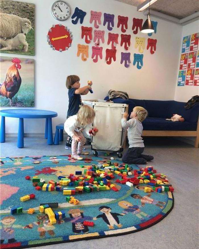 Børn bygger med duplo på en stue