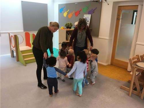 børn og voksne danser på en stue