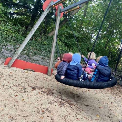 børn gynger sammen på legepladsen