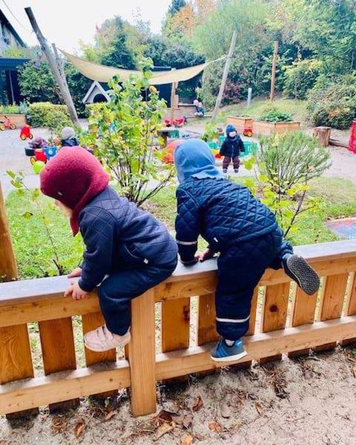 børn klatrer på hegn på legepladsen