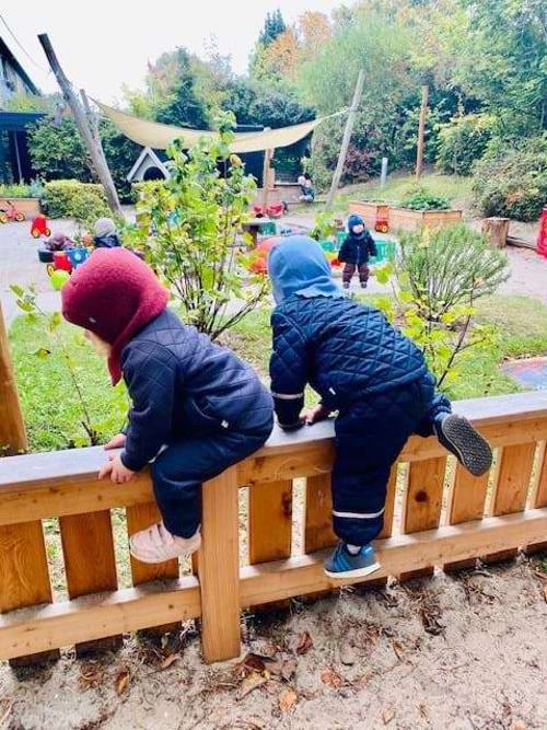 børn klatrer på hegn på legepladsen