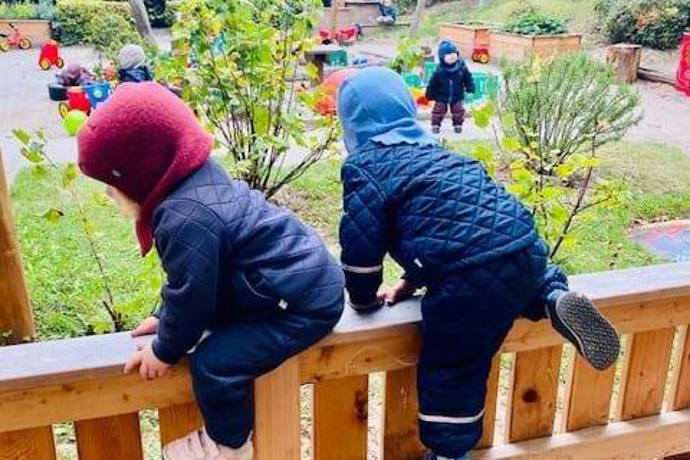 børn klatrer på hegn på legepladsen