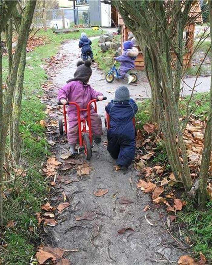 børn cykler og leger på legepladsen