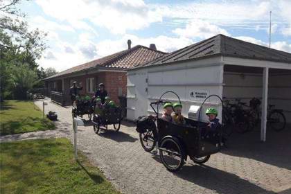 børn i ladcykler foran Vuggestuen Solsikken