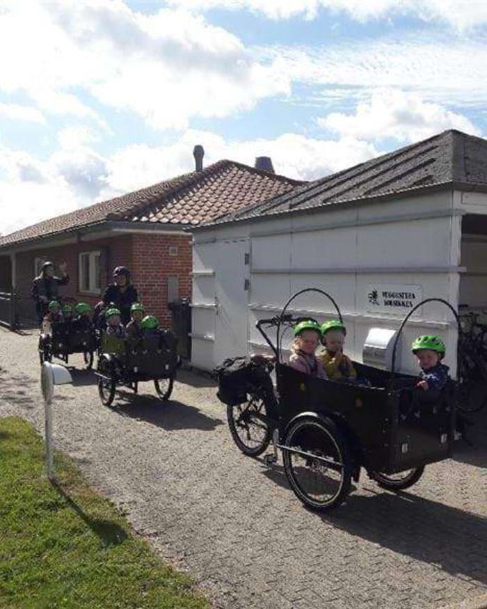børn i ladcykler foran Vuggestuen Solsikken