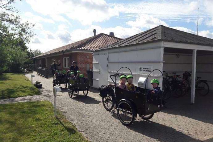 børn i ladcykler foran Vuggestuen Solsikken