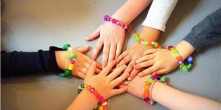 børnehænder med hjemmelavede armbånd