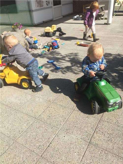 børn leger med traktorer på legepladsen