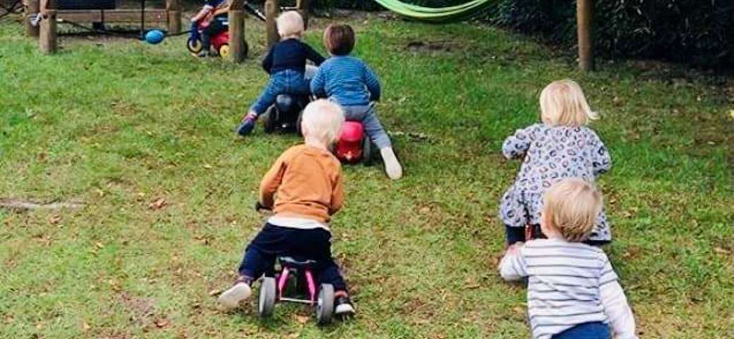 børn løber og kører på scooter på legepladsen