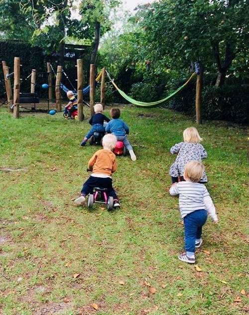 børn løber og kører på scooter på legepladsen